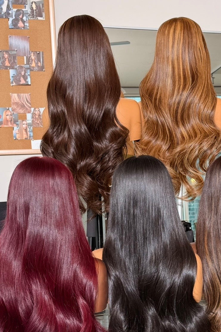 Display of wigs in various colors at a hair salon.